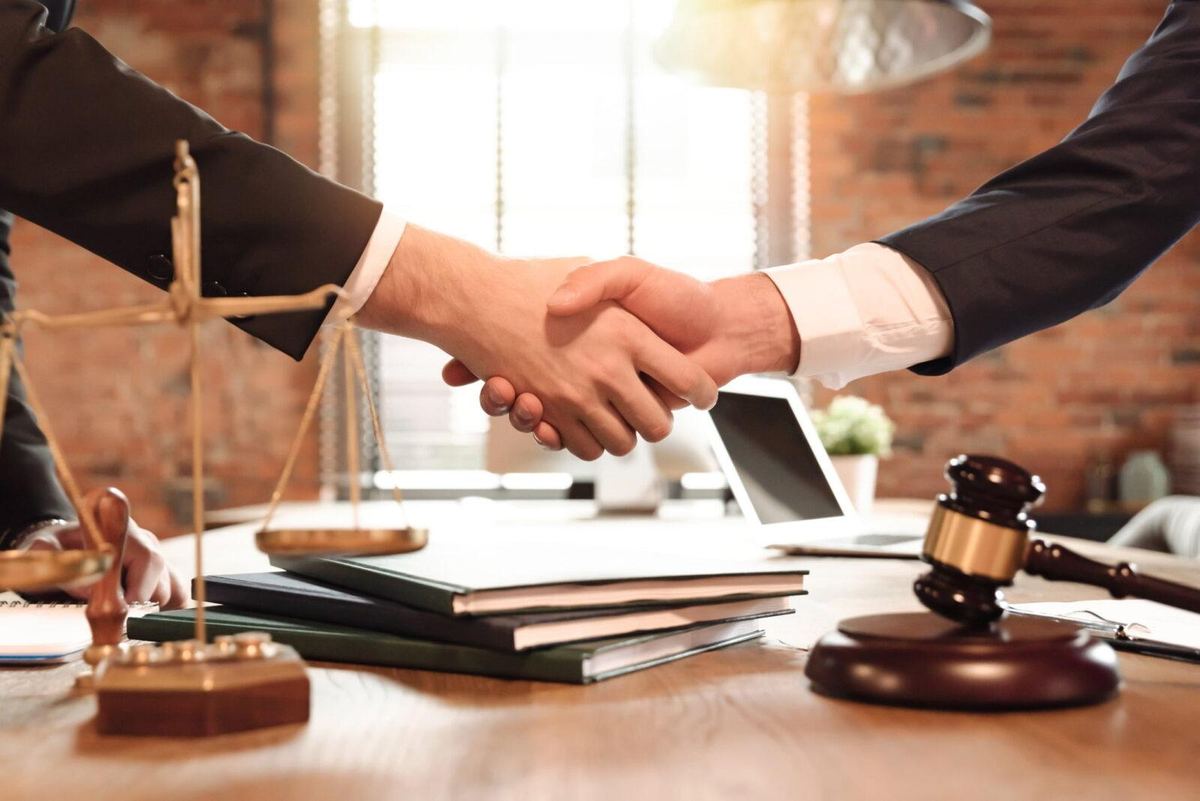 A personal injury attorney in Odessa, Texas, shakes hands and agrees to take on a case with a client.