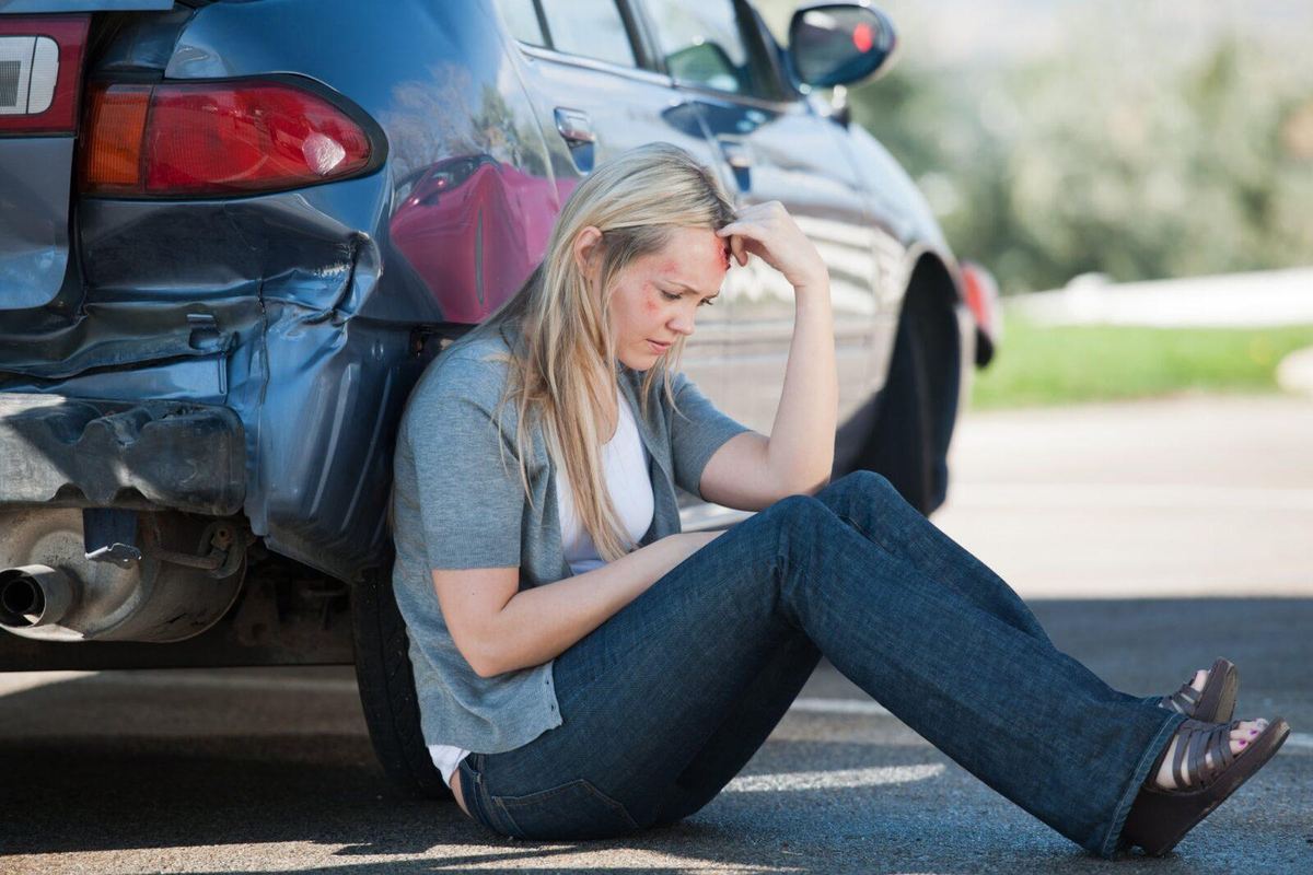 A woman leaning against her car after an accident in Odessa, TX.