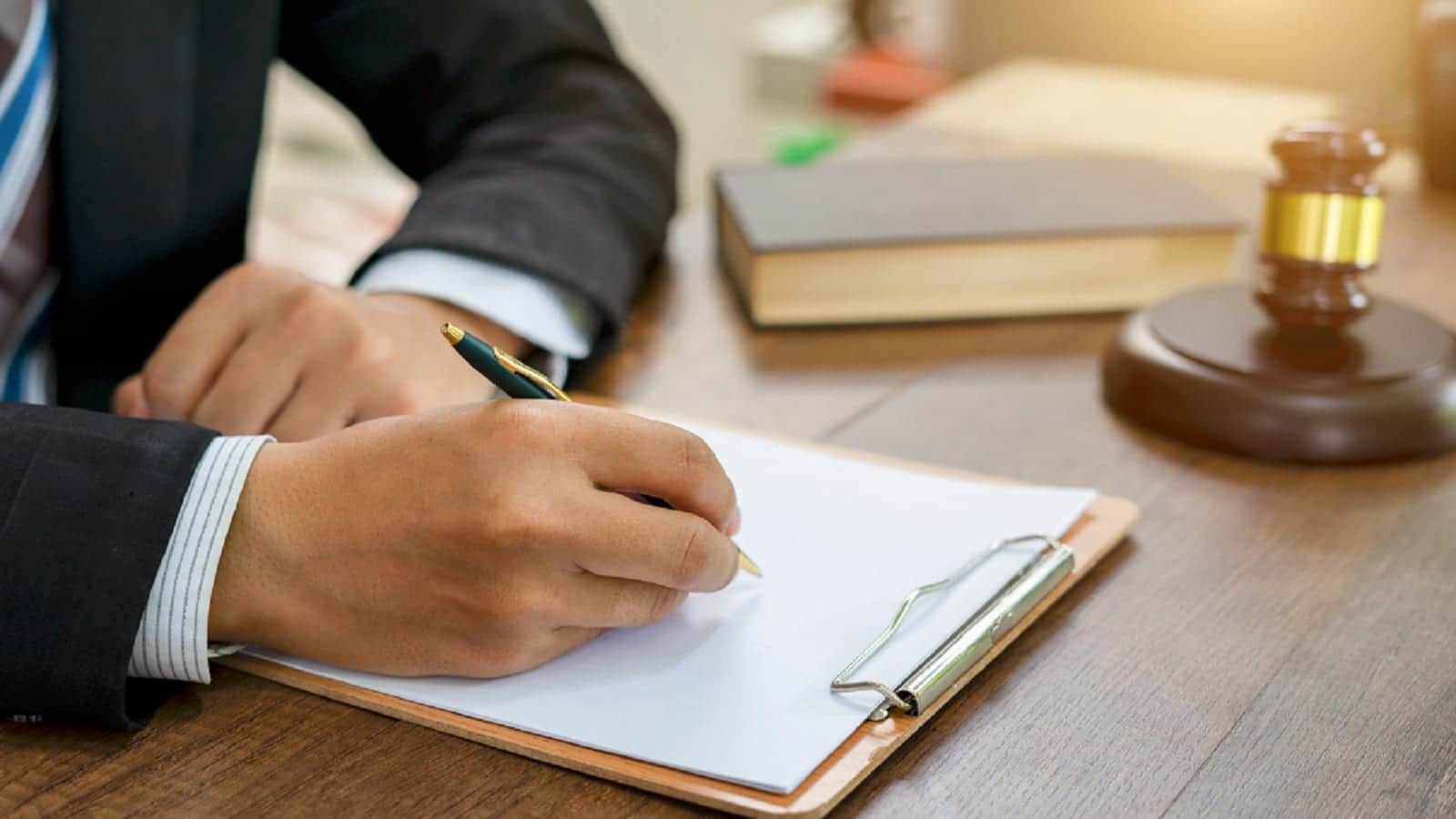 Lawyer Signing A Legal Document At His Desk